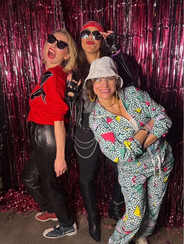 Fun 80s themed party at NYC photo booth with costumes and pink tinsel backdrop