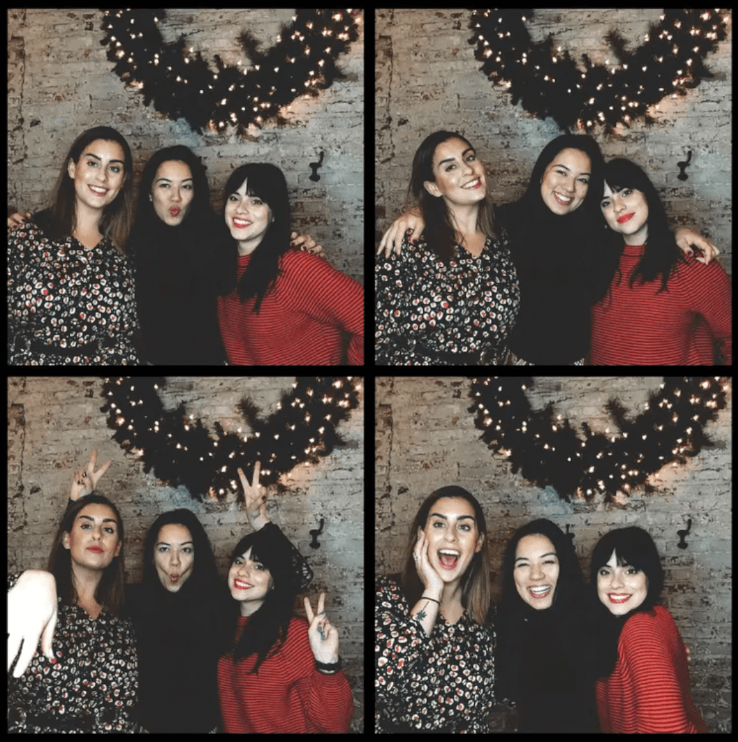 Photo strip of three friends by a brick wall with festive holiday garland lights at an NYC photo booth